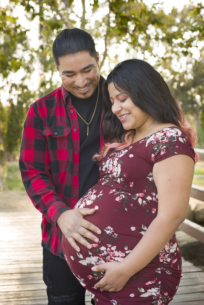 Pregnant women in a red dress with her husband